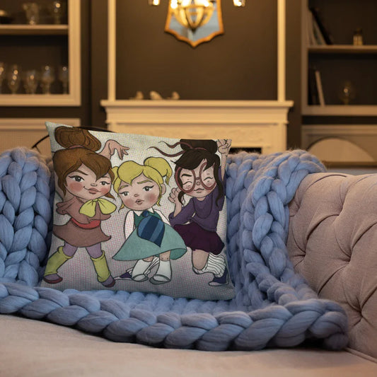 Whimsical illustrated pillow with three expressive girls on a cozy blue knit blanket