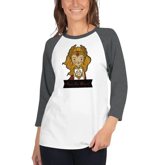 Woman wearing a raglan shirt with whimsical She-Ra illustration and 'I Have the Power!' text